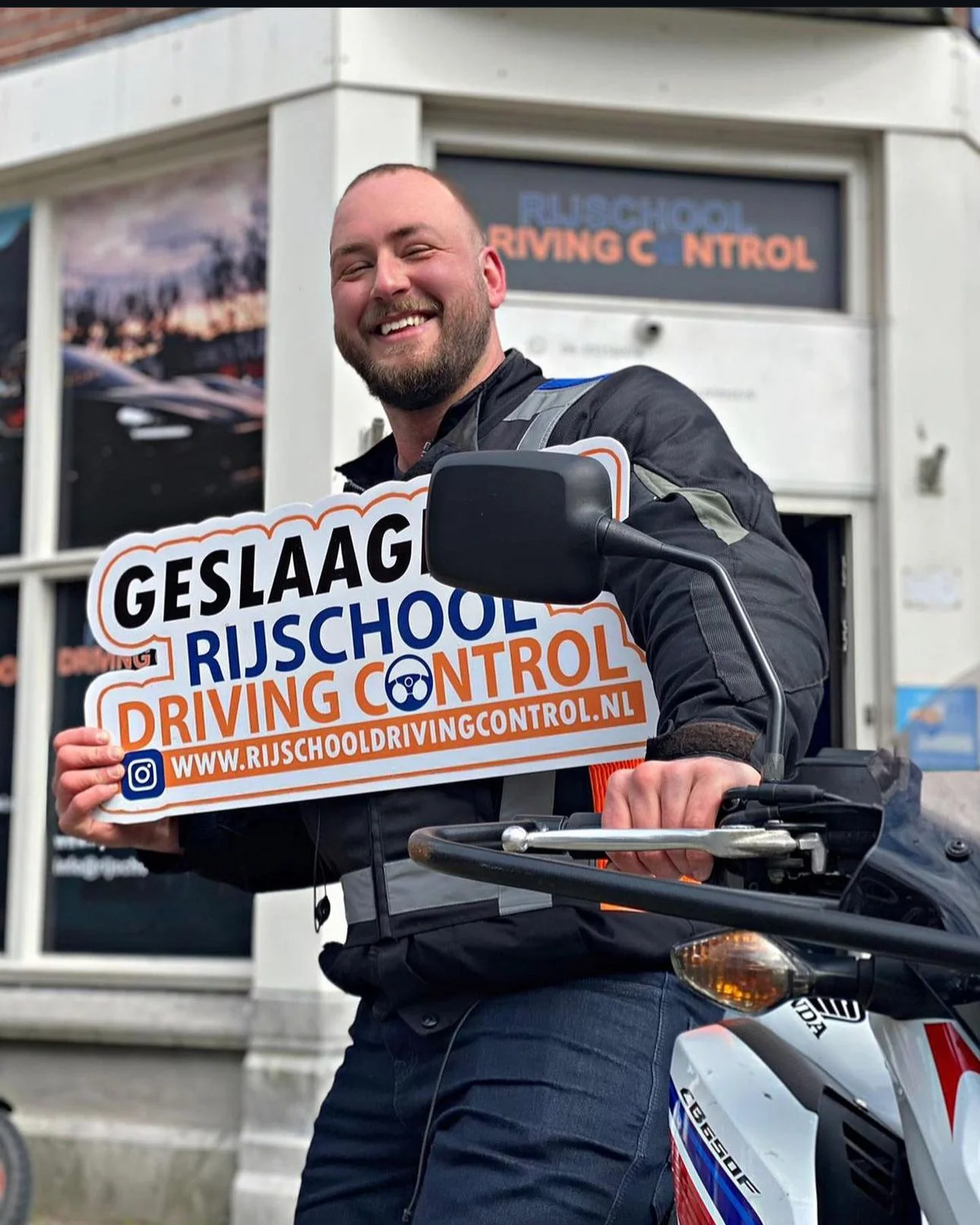 Geslaagde motorleerling Bram op Honda CB650F met Geslaagd-bord Rijschool Driving Control Rotterdam