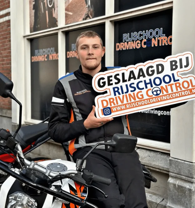 Geslaagde motorleerling Sven op motor met Geslaagd-bord Rijschool Driving Control Rotterdam